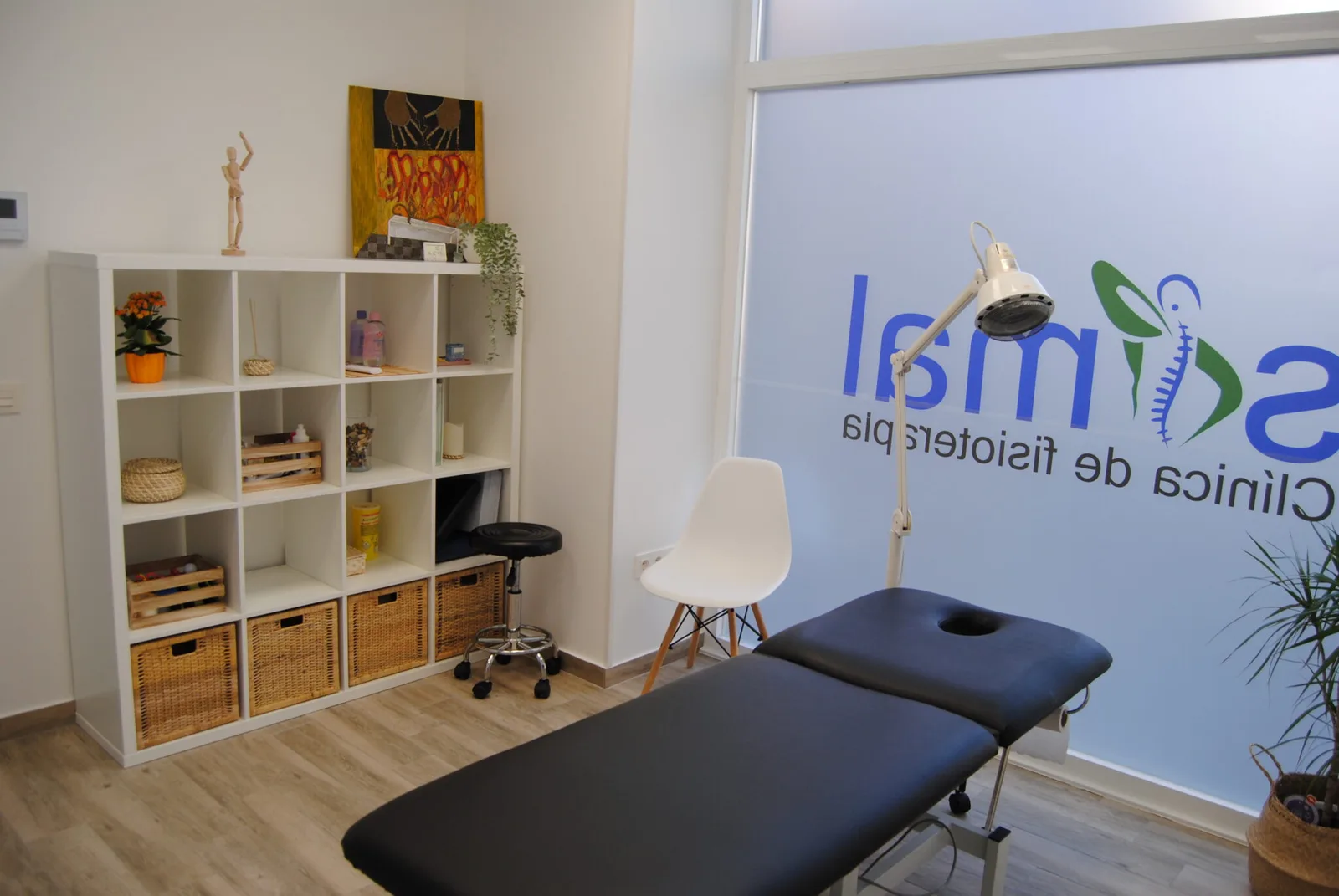 Sala de recepción y tratamiento de Simal Fisioterapia con vinilo del logo